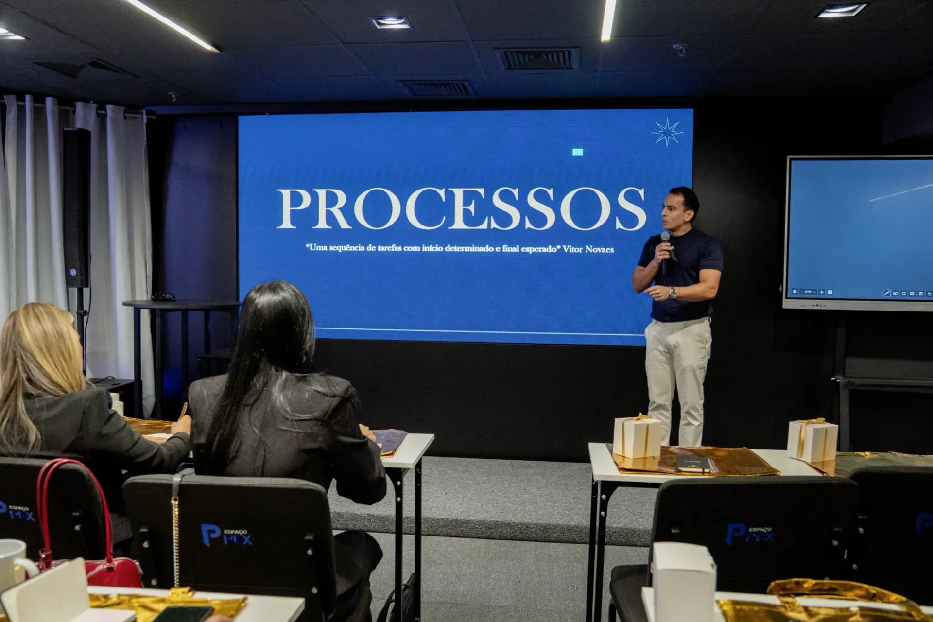 Vitor Novaes apresentando o tema Processos para a plateia